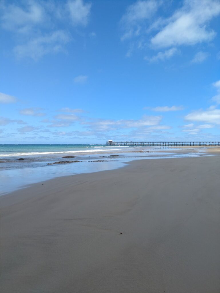 Sunny beach with a long jetty